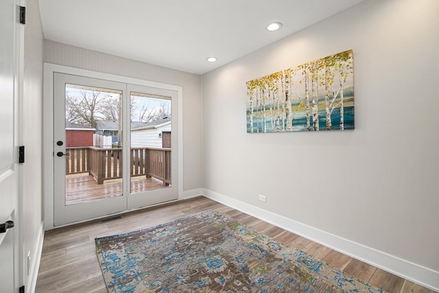 doorway with recessed lighting, wood finished floors, visible vents, and baseboards