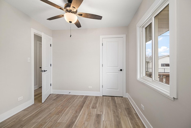 unfurnished bedroom with light wood-type flooring, baseboards, and ceiling fan