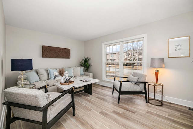 living room featuring baseboards and light wood-style flooring