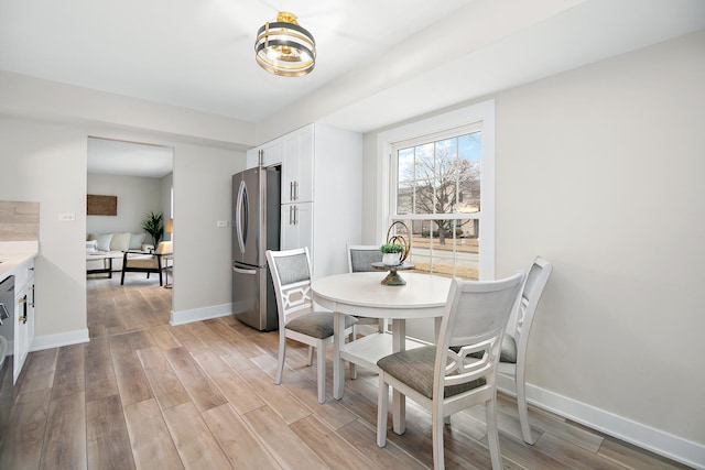 dining room featuring light wood-style floors and baseboards