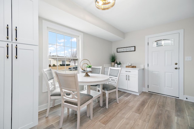 dining room with baseboards and light wood-type flooring