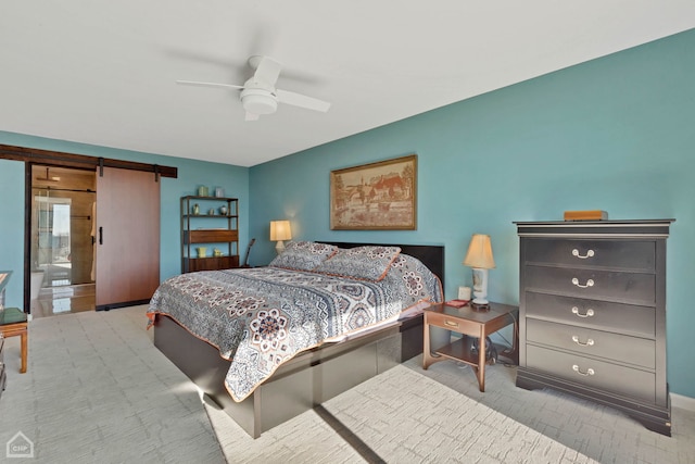 bedroom featuring ceiling fan and a barn door