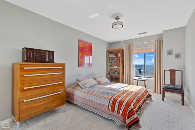 bedroom with visible vents, baseboards, and light carpet