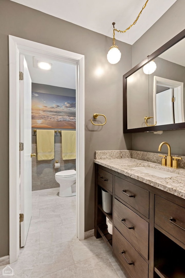 bathroom with baseboards, toilet, and vanity