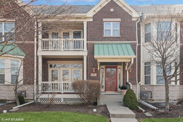 view of property featuring brick siding and a balcony