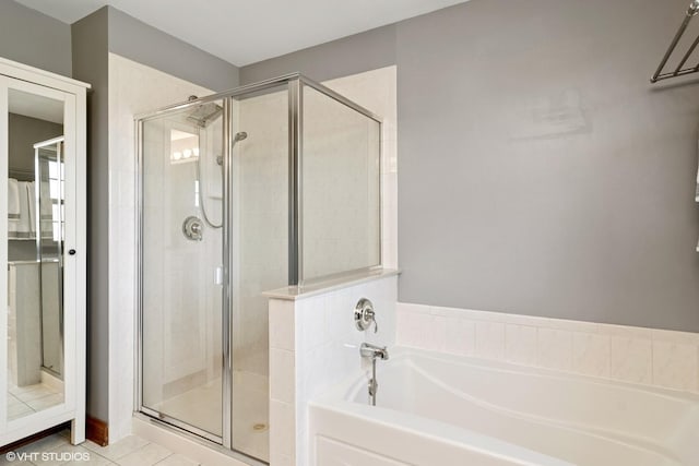 bathroom featuring tile patterned flooring, a shower stall, and a garden tub