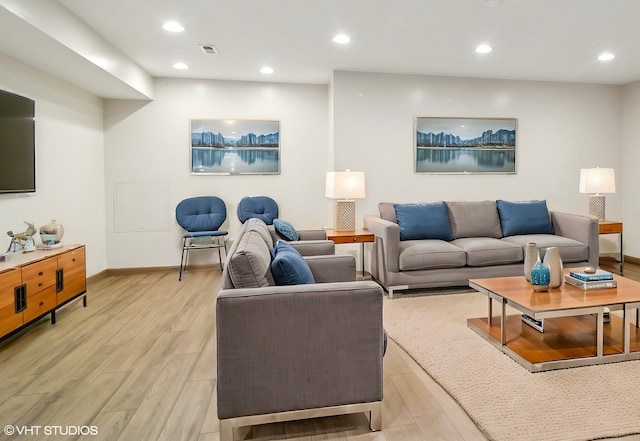 living area with light wood finished floors, visible vents, recessed lighting, and baseboards