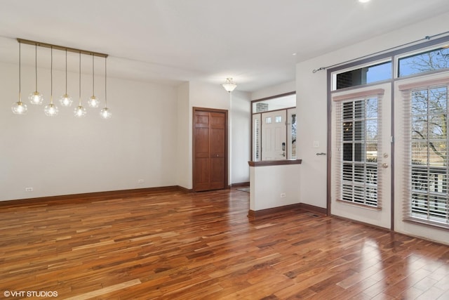 unfurnished room featuring baseboards and wood finished floors