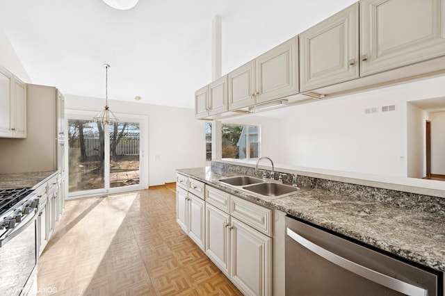 kitchen featuring vaulted ceiling, a wealth of natural light, appliances with stainless steel finishes, and a sink