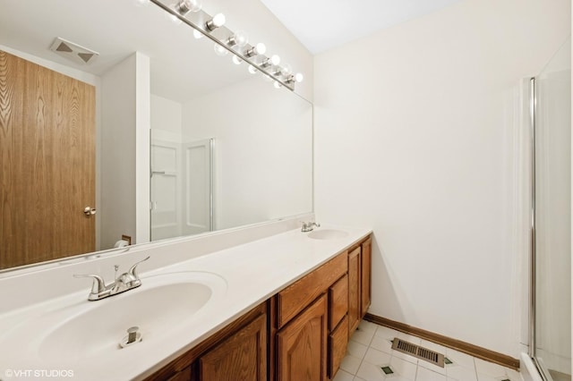 full bath featuring double vanity, visible vents, baseboards, and a sink