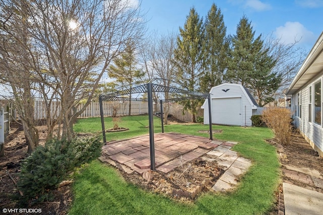 view of yard featuring an outdoor structure, a storage unit, a patio area, and a fenced backyard