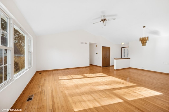 unfurnished living room with visible vents, lofted ceiling, baseboards, and light wood-style flooring