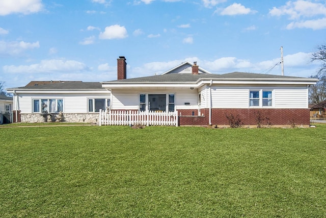 view of front of property featuring brick siding, a chimney, a front yard, and fence