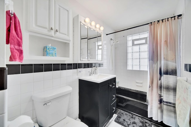 full bathroom with vanity, tile walls, toilet, and shower / bath combo