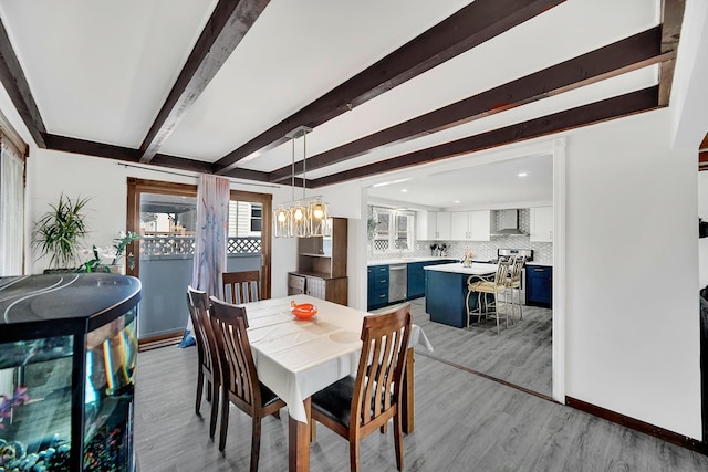 dining space with beamed ceiling, baseboards, light wood-style flooring, and a chandelier