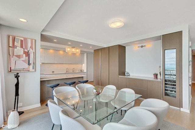 dining space with recessed lighting, baseboards, and light wood finished floors