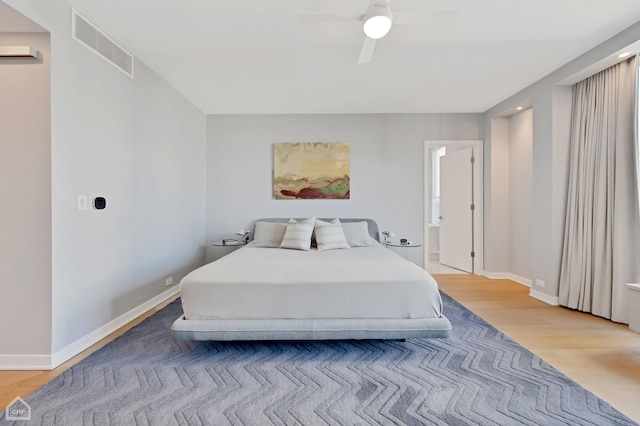 bedroom featuring visible vents, baseboards, light wood-style flooring, and a ceiling fan