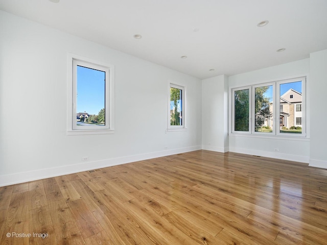 spare room with recessed lighting, baseboards, and light wood-style floors