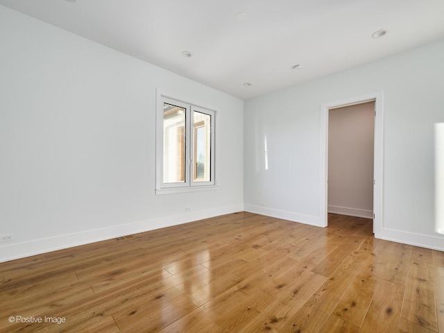 empty room with light wood finished floors and baseboards