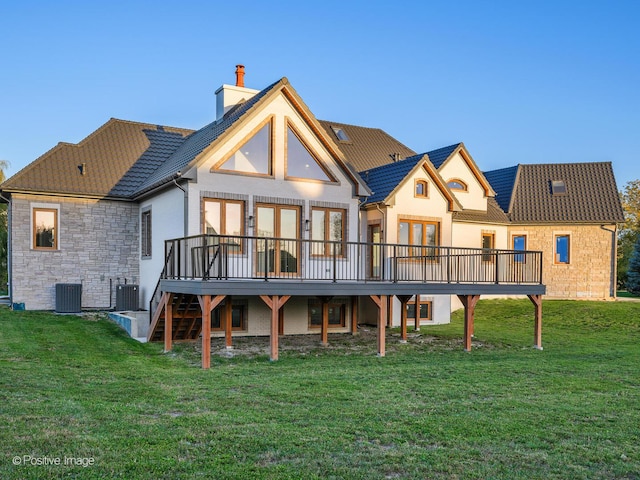 rear view of house with cooling unit, a yard, a deck, and a chimney