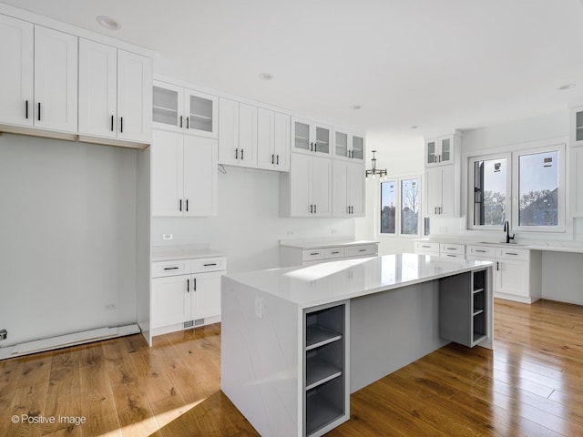 kitchen featuring white cabinetry, open shelves, wood-type flooring, and a kitchen island