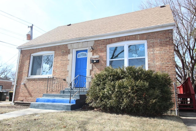 view of front of property with brick siding and a shingled roof