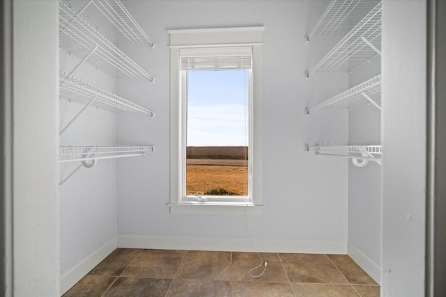 spacious closet with dark tile patterned flooring