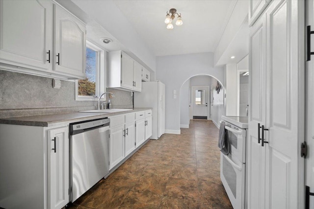 kitchen featuring backsplash, arched walkways, white cabinets, white appliances, and a sink