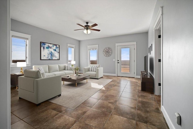 living room with baseboards and a ceiling fan