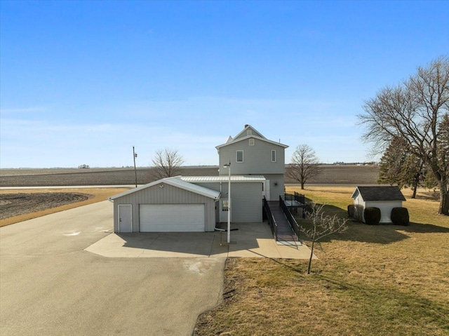 view of front of home featuring a shed, a garage, a front yard, and an outdoor structure