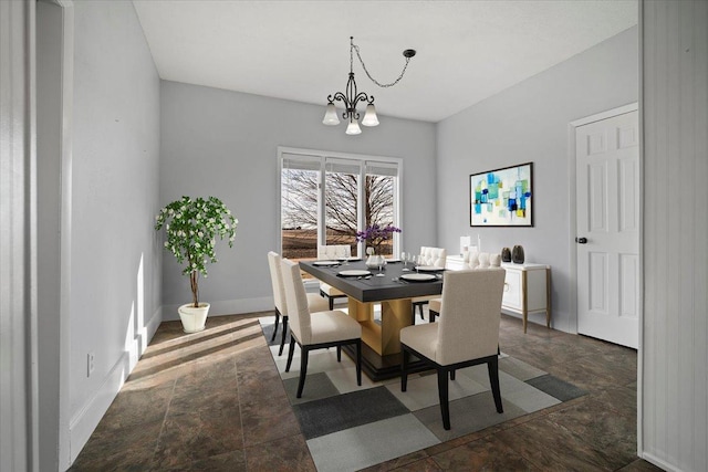 dining space featuring baseboards and an inviting chandelier