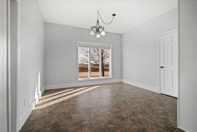 unfurnished dining area with a notable chandelier and baseboards