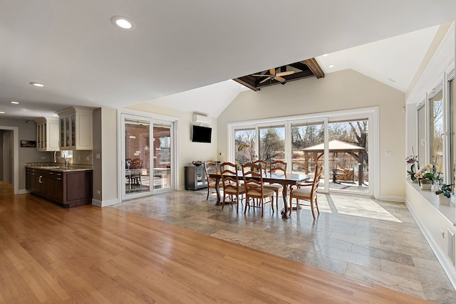 dining area with a wealth of natural light, light wood-style flooring, baseboards, and lofted ceiling