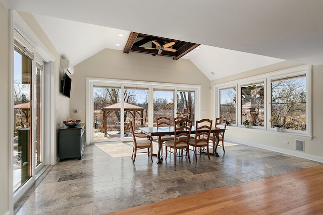 dining room featuring lofted ceiling with beams, stone tile floors, and plenty of natural light