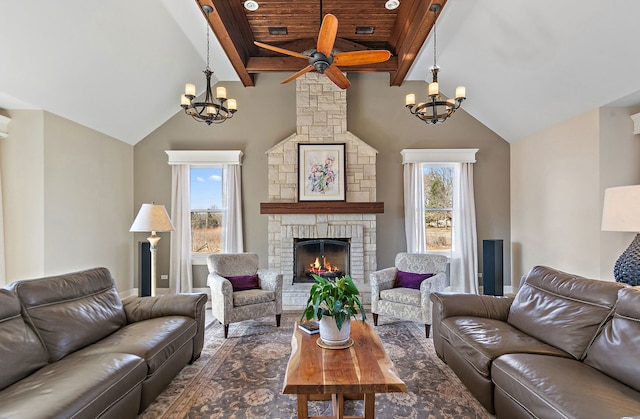 living area with a wealth of natural light, ceiling fan with notable chandelier, a fireplace, and lofted ceiling with beams