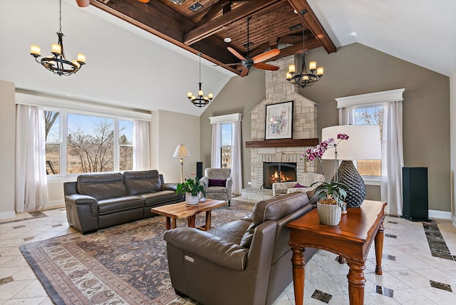 living area with baseboards, high vaulted ceiling, a stone fireplace, beamed ceiling, and ceiling fan with notable chandelier