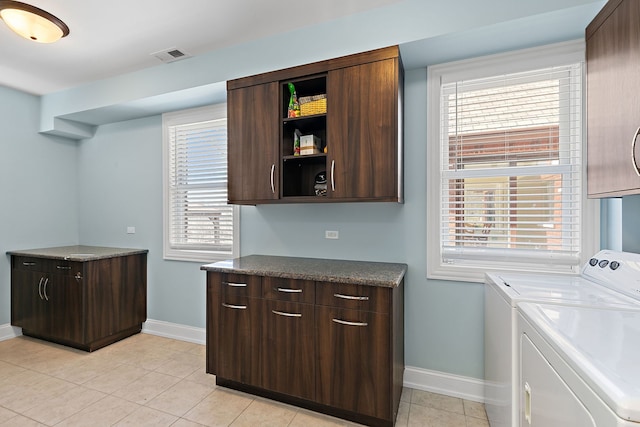 laundry room featuring visible vents, independent washer and dryer, cabinet space, light tile patterned flooring, and baseboards