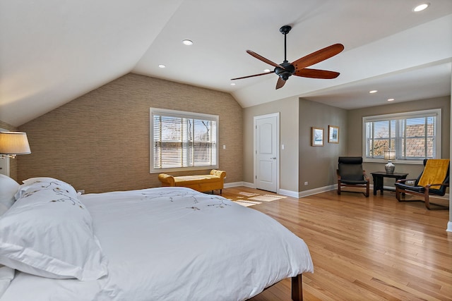 bedroom featuring an accent wall, multiple windows, and light wood-style floors