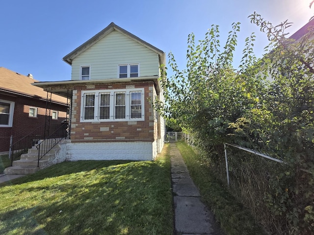 back of house featuring a lawn and fence