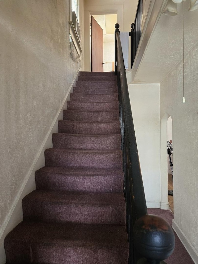 stairway featuring a textured wall