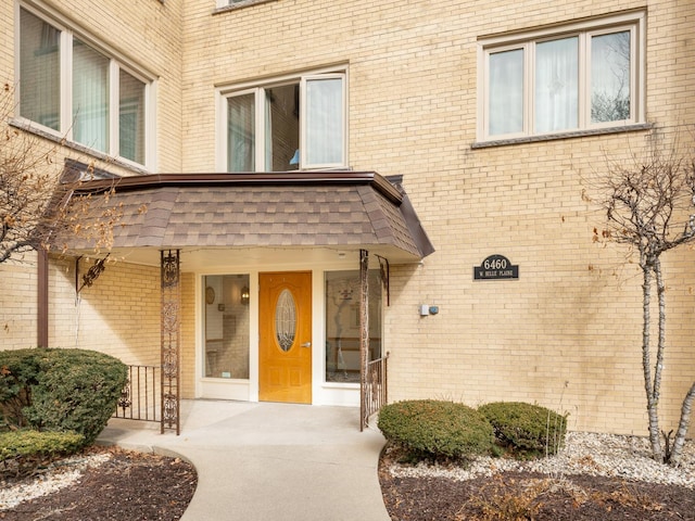 property entrance featuring brick siding and covered porch