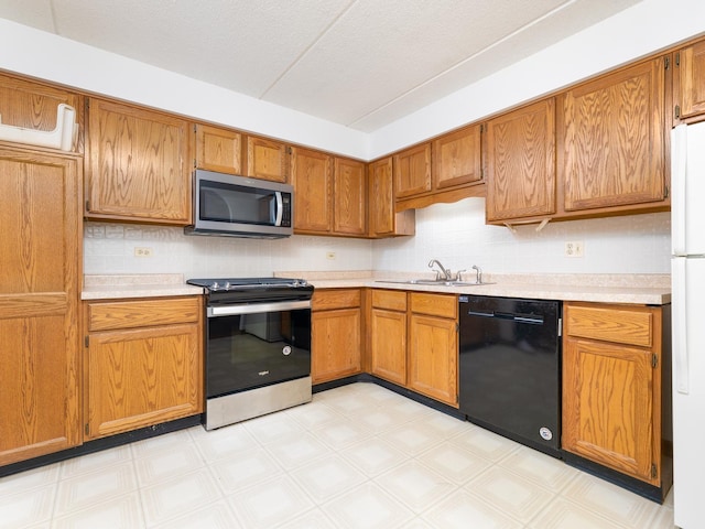 kitchen with light countertops, light floors, appliances with stainless steel finishes, and a sink