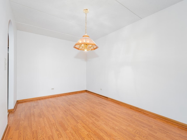 spare room with baseboards and light wood-style flooring