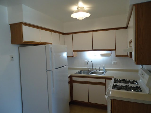 kitchen featuring a sink, white appliances, and light countertops