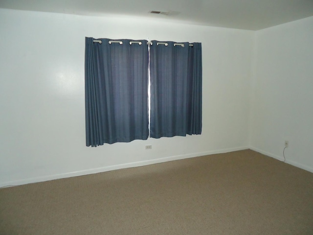 spare room with visible vents, baseboards, and carpet floors