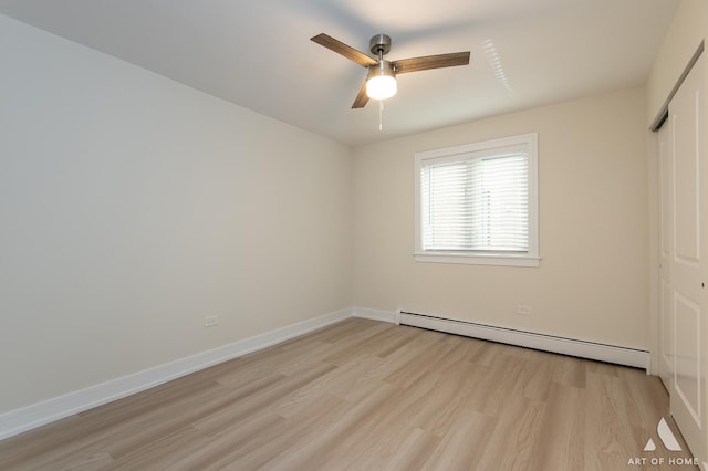 unfurnished bedroom featuring a closet, baseboards, baseboard heating, and light wood-style flooring