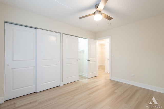 unfurnished bedroom with two closets, baseboards, light wood-style floors, and a ceiling fan