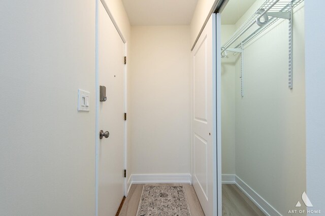 hall featuring baseboards and light wood-style flooring