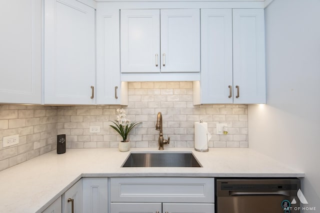 kitchen featuring a sink, white cabinetry, decorative backsplash, light stone countertops, and dishwasher