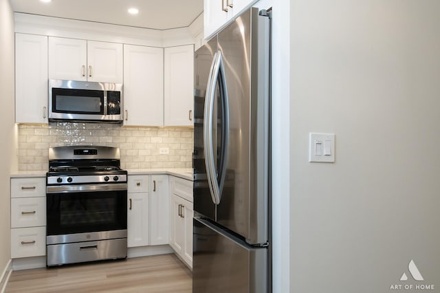 kitchen featuring decorative backsplash, light countertops, white cabinetry, and appliances with stainless steel finishes